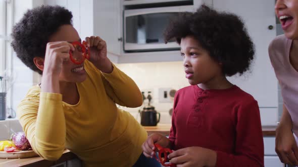 Mixed race lesbian couple and daughter preparing food in kitchen