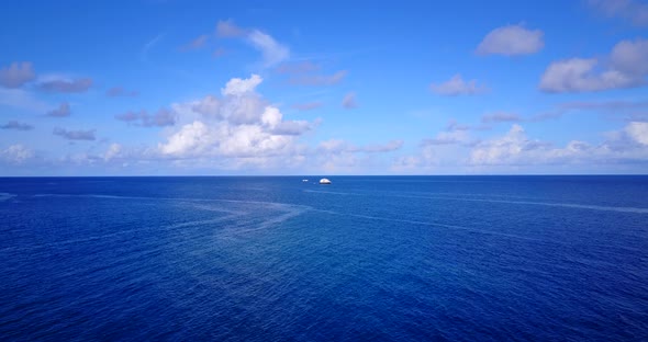 Wide aerial tourism shot of a white sandy paradise beach and blue sea background in colourful