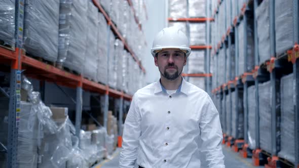 Worker male warehouse worker engineer in a helmet working on the construction site of the warehouse