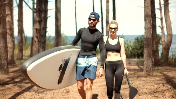 Couple After Swim Surfing Boat Fitness Workout With Oar.Travel SUP Water Tourism Holiday Vacation.
