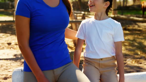 Mother and daughter interacting with each other in ranch