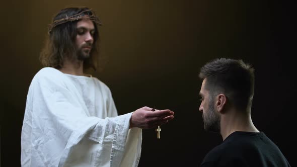 Jesus in Crown of Thorns Giving Wooden Cross Necklace to Praying Man, Hope