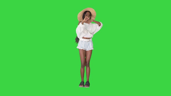Cheerful African American Girl in a Straw Hat Dancing on a Green Screen Chroma Key