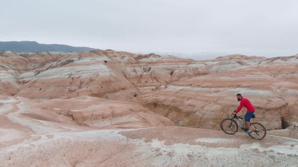 Drone Shot of Bicyclist Ride in Canyon Desert Mountains in Kazakhstan