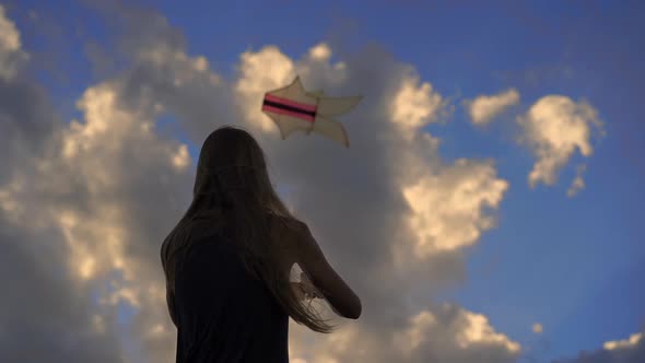 Slowmotion Shot of a Young Woman on a Tropical Beach with a Kite During a Sunset Time