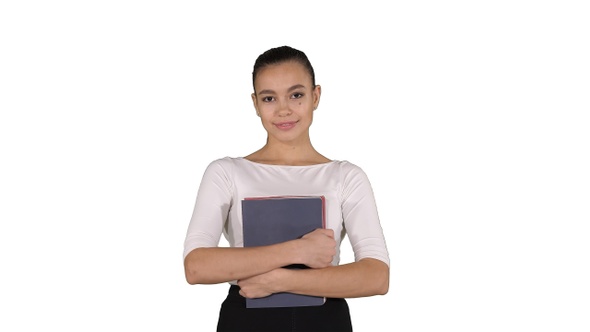 Beautiful young woman with notebooks walking on white background.