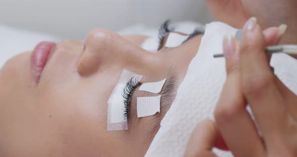 Female having eye lash extension in beauty salon