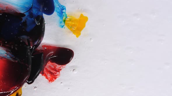 Transparent Space Liquid is Filled with Drops of Red Blue Yellow and Green Paint