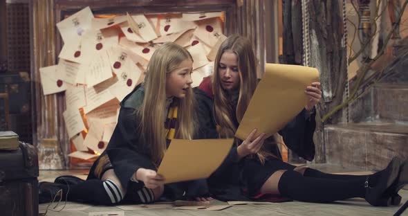 Two Young Students of the Magic School are Reading Scrolls in Class