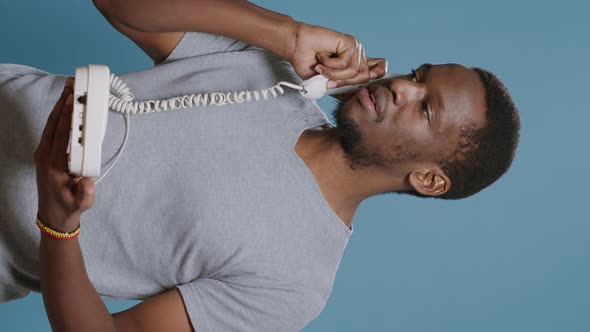 Vertical Video Young Man Answering Landline Phone Call in Studio