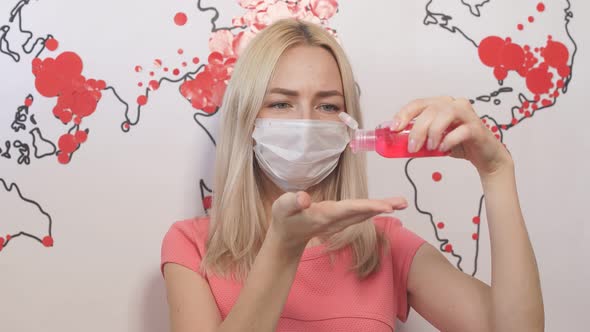 Blonde Girl in Protective Mask Uses Antiseptic for Hands, Girl Stands Against Background of Map