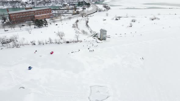 Overhead of multiple kids and adults ice skating on frozen Martindale Pond, Port Dalhousie, Ontario