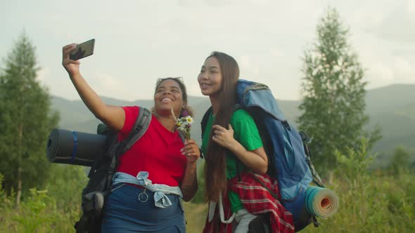 Carefree Pretty Multiethnic Female Travelers Taking Selfie Shot in Mountain at Sunset