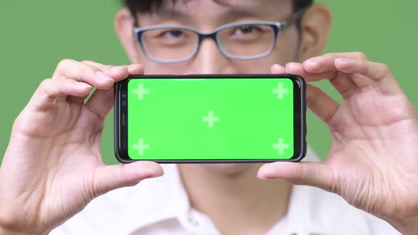 Young Asian Businessman Showing Phone To Camera