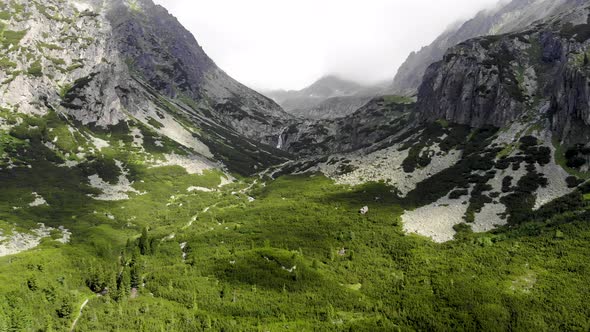 AERIAL: Descending into Green Forest Valley with Two Mountains in High Tatras Region in Slovakia