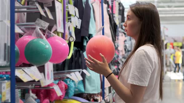 Girl Choosing a Ball in the Hypermarket