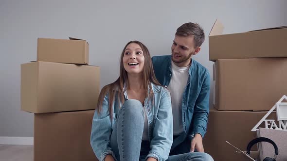 Couple in Love Which Having Fun Together in New flat Among Many Boxes After Moving