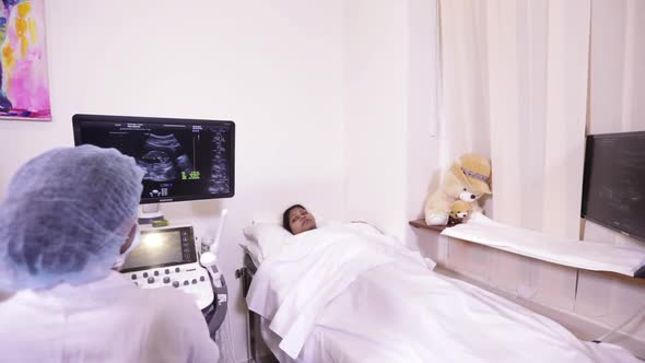 Indian Mother And Ultrasound Operator Viewing Her Baby