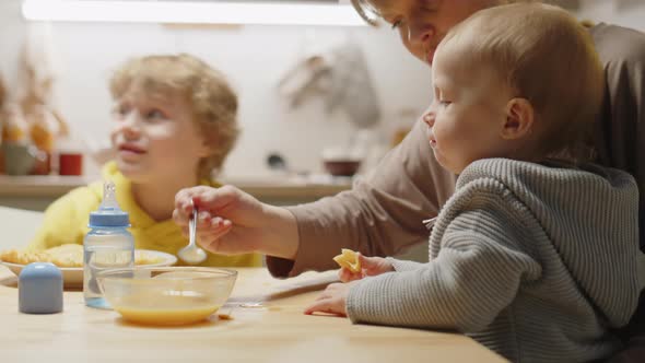 Mother Feeding Baby Son at Home