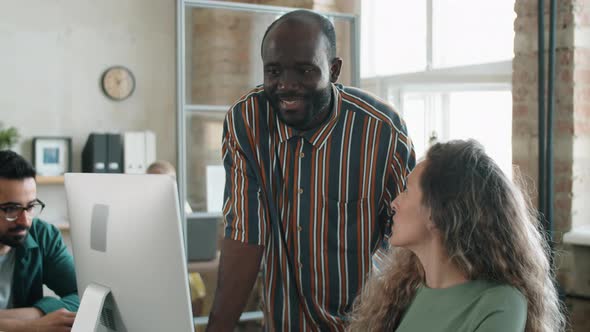 Black Man and Caucasian Woman Discussing Business Project on Computer