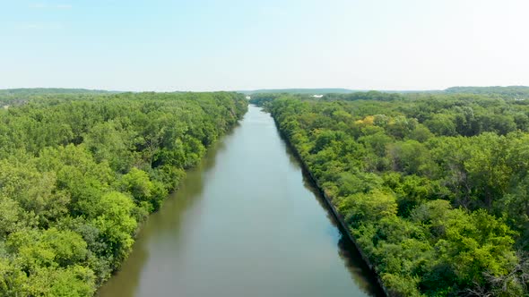 aerial drone toward a horizon over shipping canal and blue sky 4k