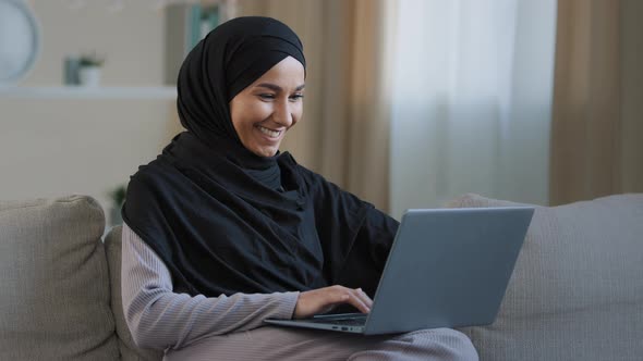 Smiling Arab Islamic Woman Muslim Young Girl in Hijab Freelancer Student Using Laptop Leaning on