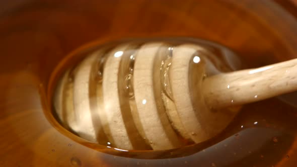 Using Spoon for Honey in Wooden Bowl, Close Up