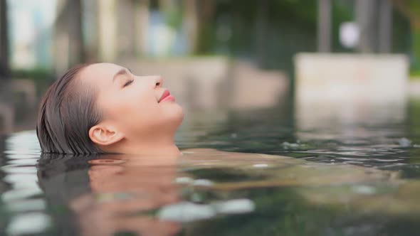 Young asian woman enjoy around outdoor swimming pool for leisure