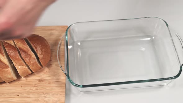 Woman Puts Pieces of Bread in a Tray