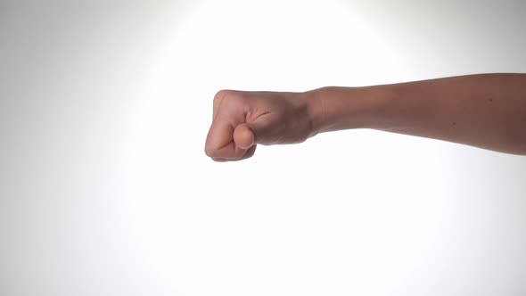 Women's Hand Shows Dislike It Thumb Down on a White Background