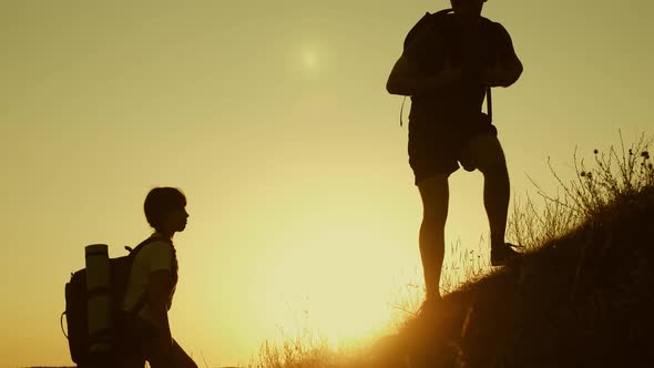 Father Holds Out His Hand Helping Children Climb Mountain. Family of Tourists with Kids Traveling at