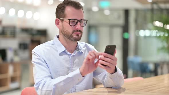 Businessman Using Smartphone in Office 