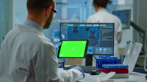 Researcher Holding and Looking at Tablet with Chroma Key