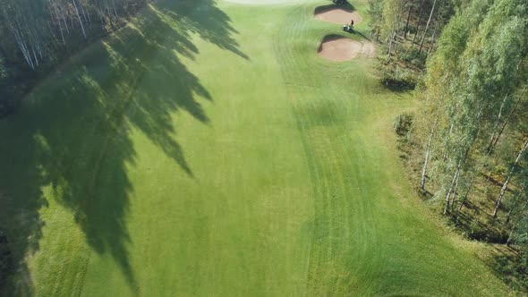 Summer Sunny Day Aerial View of Golf Course in Forest Area Golf Club Lawn Mower Car Mows the Lawn