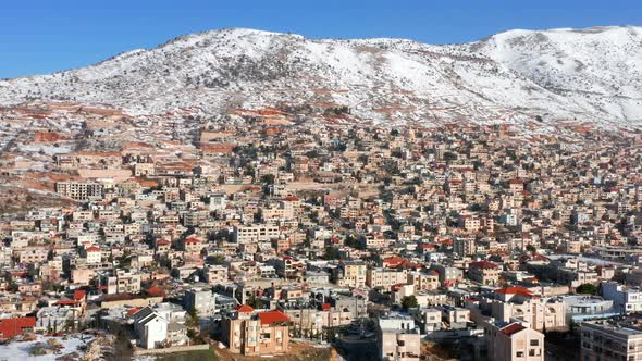 Hermon mountain ridge covered with snow during 2022 winter, with the town houses of Majd al Shams.