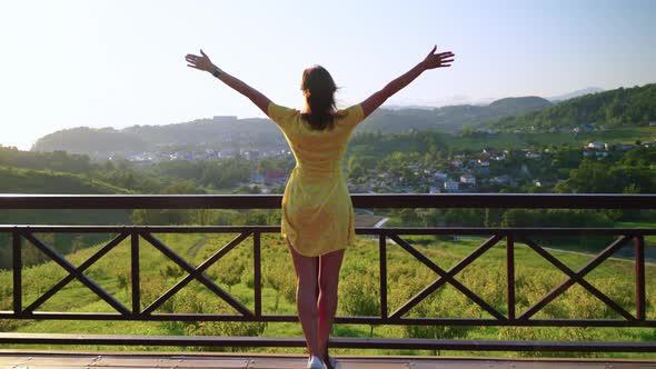 Admired and Happy Woman Looking at Countryside with Raised Hands