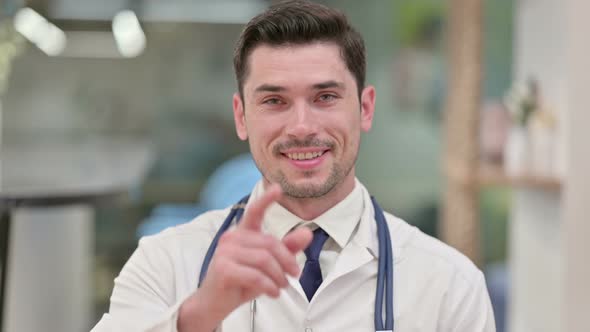 Young Male Doctor Showing Call Me for Help Sign 