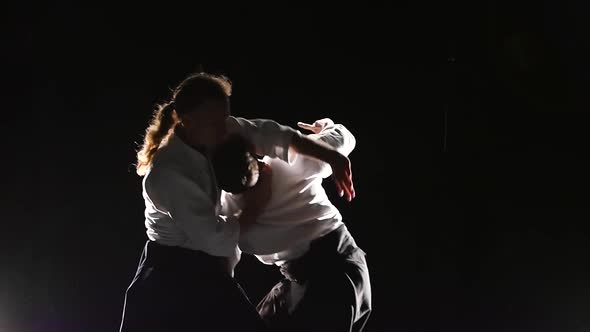 Two Fighters Participants of the Training in Special Clothes of Aikido Hakama Work Out the Methods