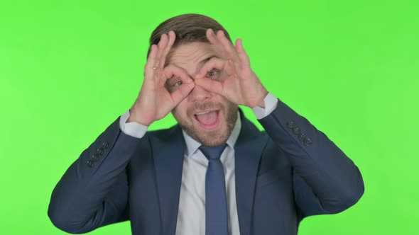 Young Businessman Searching with Handmade Binocular Green Screen