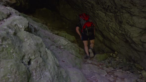 Hiker walking in a cave. People in nature concept.