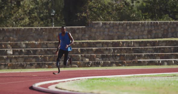 Disabled mixed race man with prosthetic legs running on race track