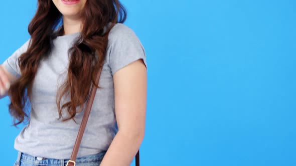 Beautiful woman with hand bag posing on blue background
