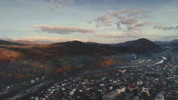 Town on Winding Mountain River Bank and Green Forests