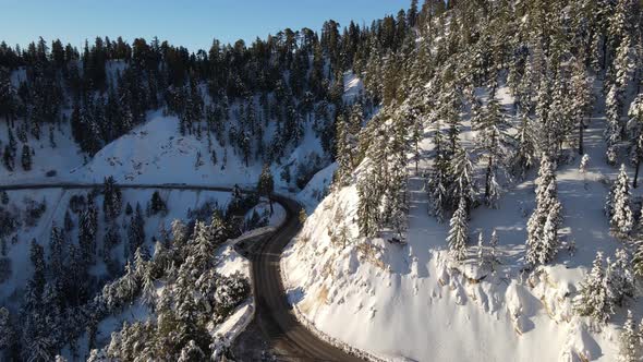 Aerial of a road through the mountains after a snow