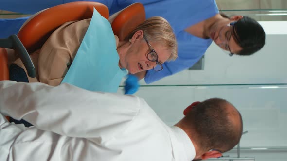 Vertical Video Nurse Putting Dental Bib to Old Woman