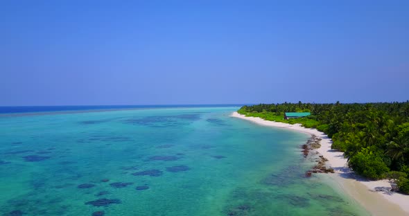 Tropical birds eye abstract shot of a white sandy paradise beach and aqua blue ocean background in 4