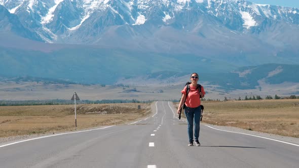 Woman Traveler with Backpack Walking on the Road