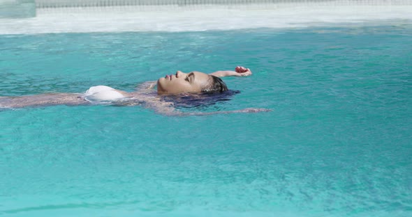 Beautiful woman swimming in swimming pool