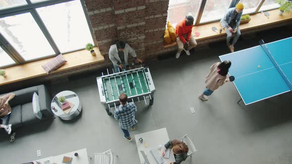 Top View of Colleagues Playing Foosball and Ping Pong Indoors in Modern Coworking Space
