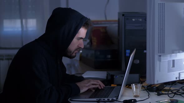 Hacker typing fastly on keyboard at night - cyber crime, data theft